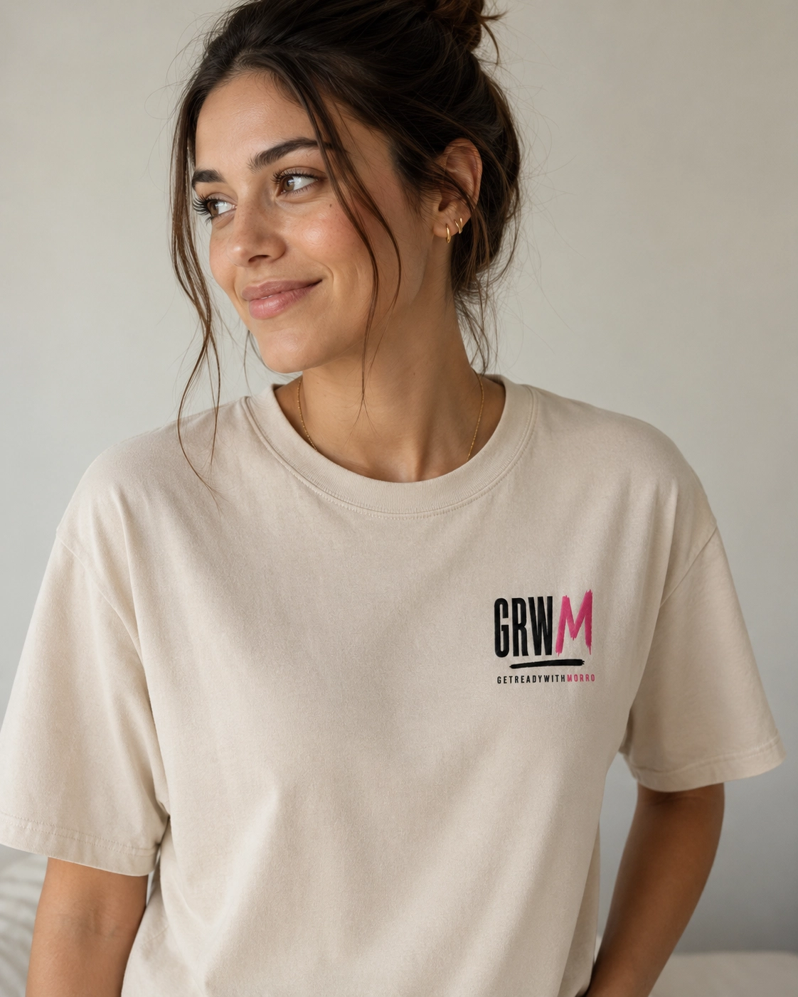 Mujer llevando la camiseta GRWM crema con bordado al pecho