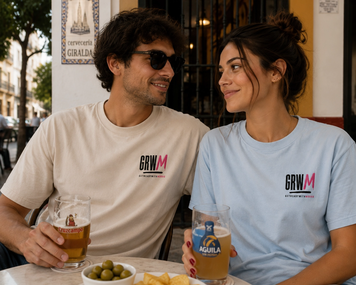 Pareja con camisetas GRWM en una terraza de Sevilla